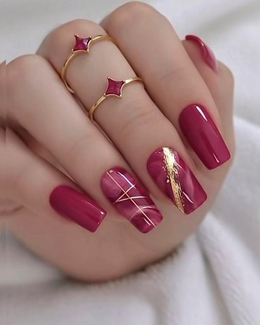 Unhas vinho com detalhes dourados e pedrarias