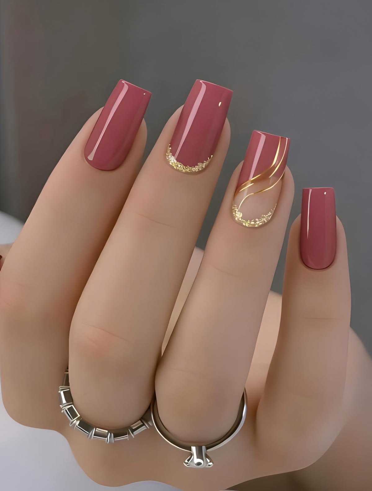 Unhas rosa queimado com delicados detalhes dourados